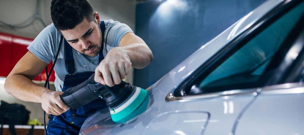 Technician polishing a vehicle after auto body repair